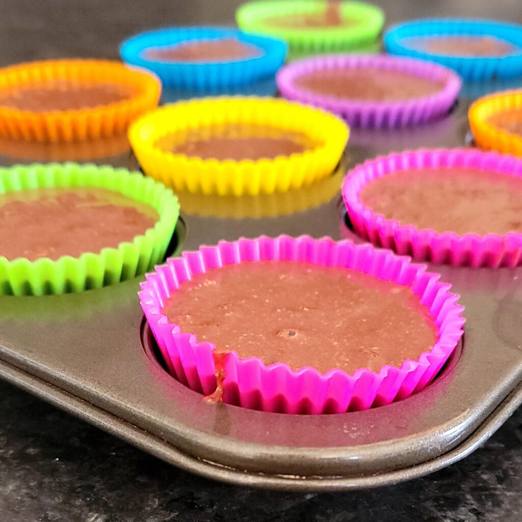 Healthy muffins batter distributed in a muffin tin.